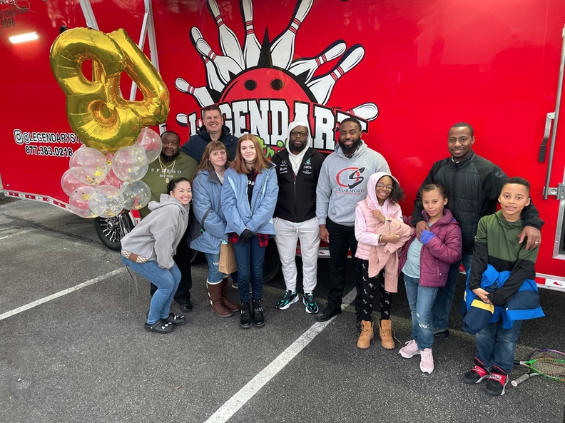 Real family celebrating a birthday event in front of the Legendary Strikes mobile bowling truck
